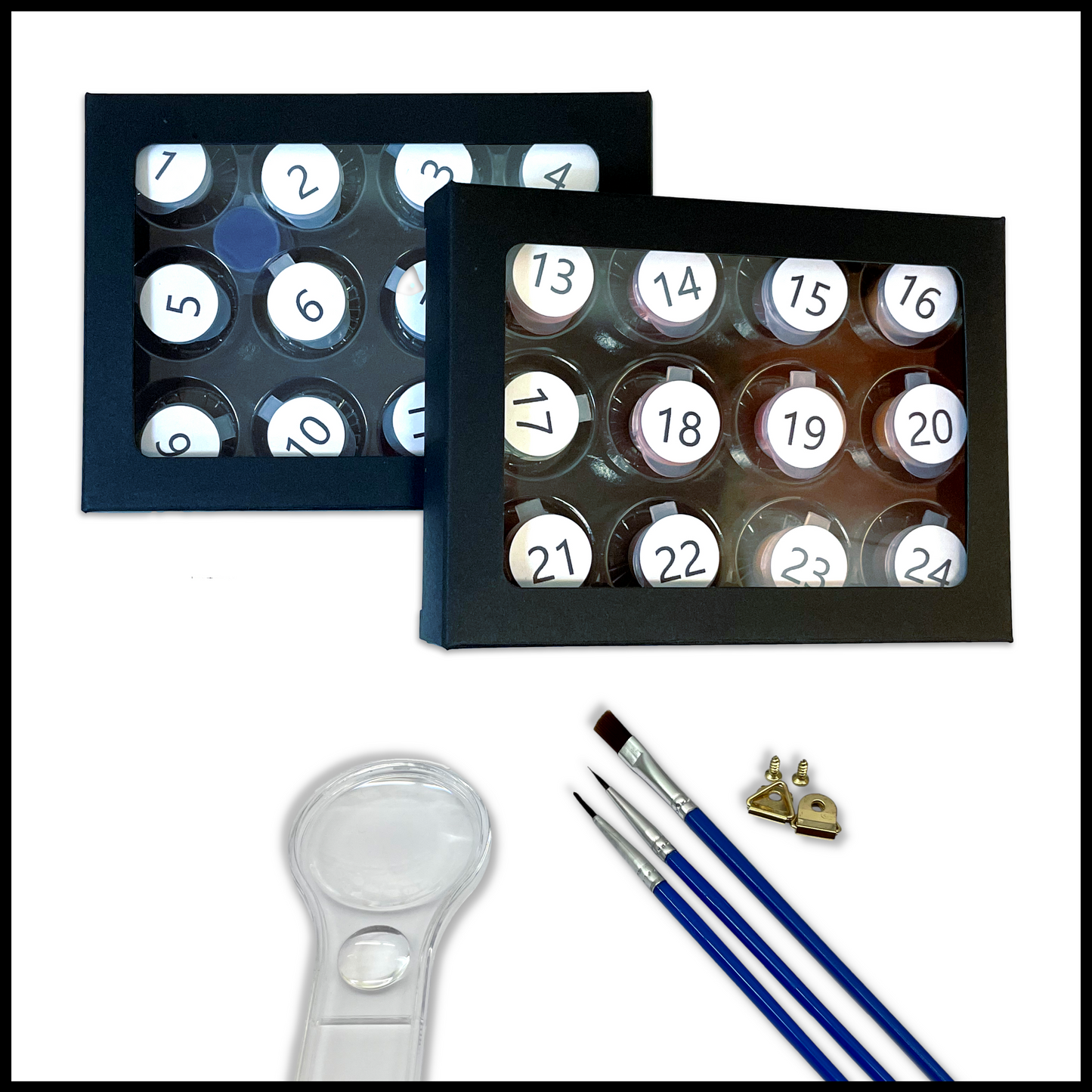 Set of paints, brushes and a magnifying glass