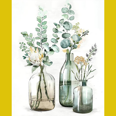 A painting kit with three glass bottles of different sizes on a canvas, with eucalyptus leaves and other small flowers arranged inside the bottles.
