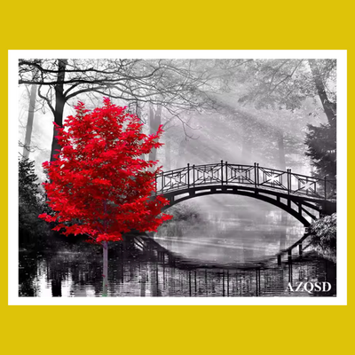 Red tree by a bridge over water 