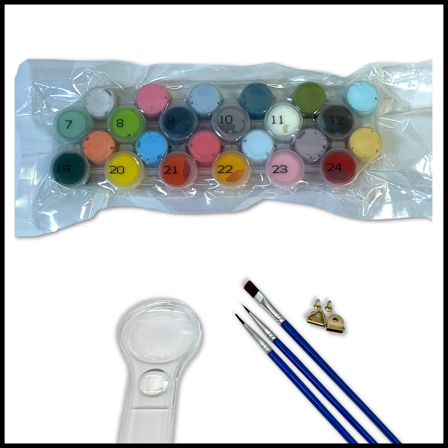 Set of paints, brushes and a magnifying glass