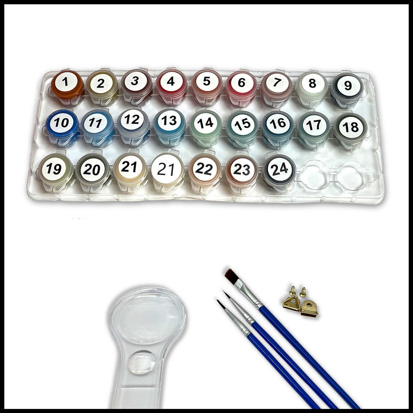 Set of paints in a plastic holder with brushes and a magnifying glass on a white background