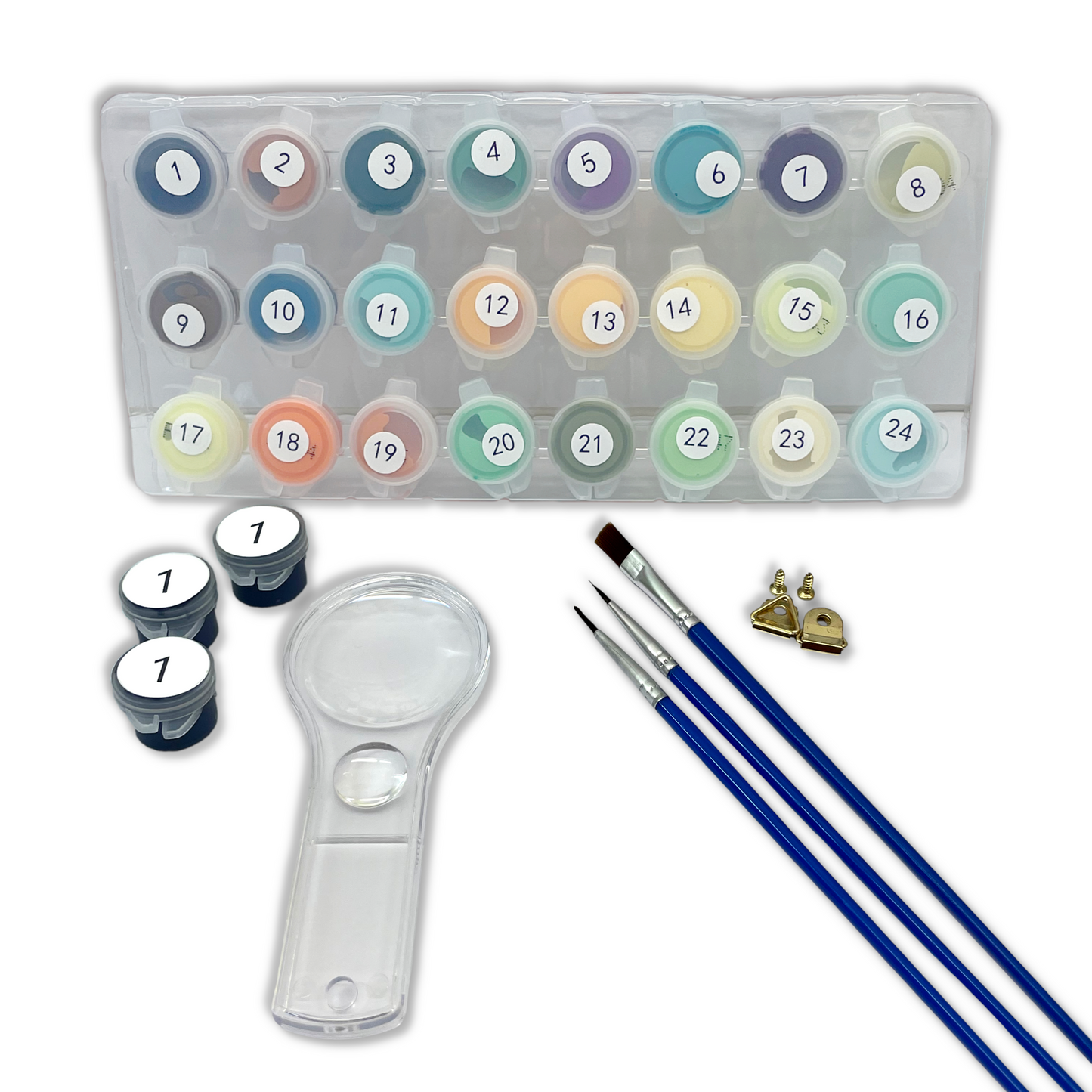 Art supply set with paint tubes, brush, and magnifying glass on white background