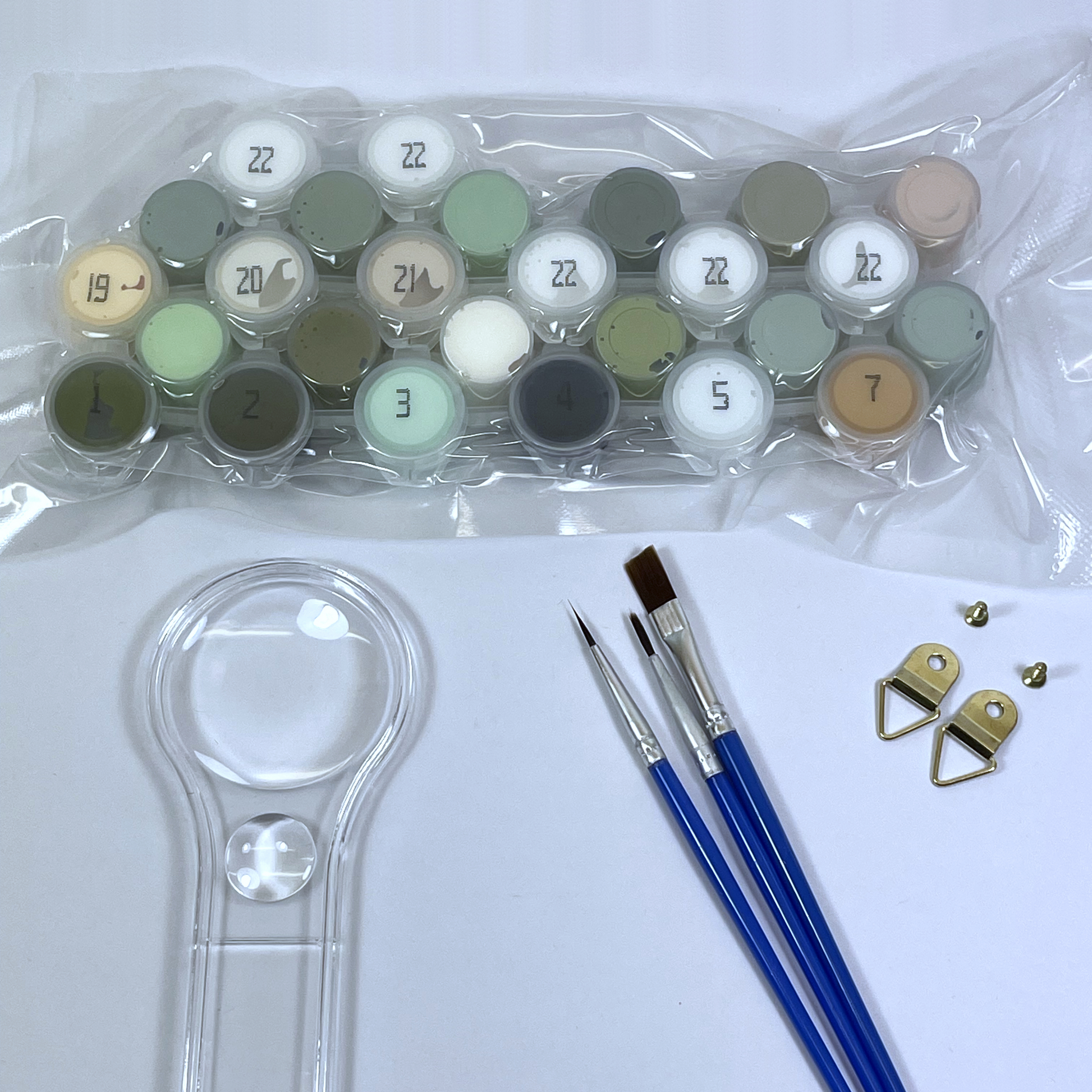 Set of paint pots, brushes, and a magnifying glass on a white background