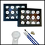 Set of paints, brushes and a magnifying glass