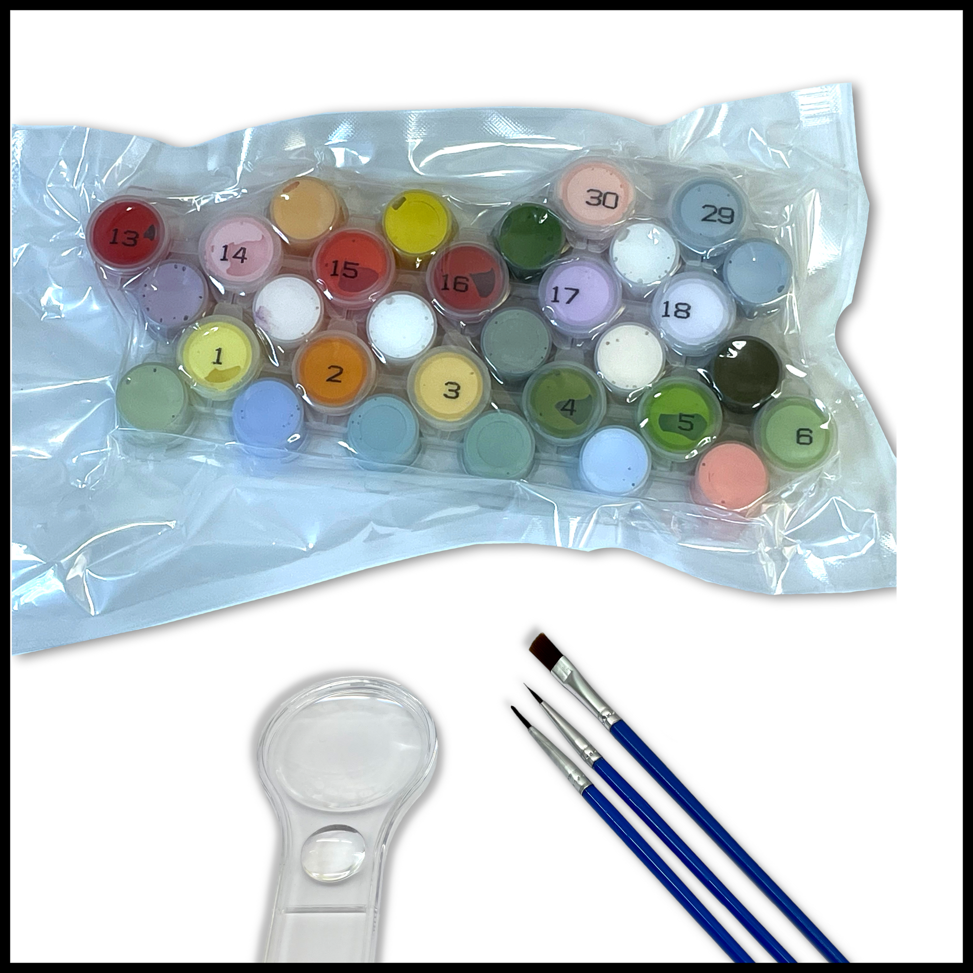 Set of paints  with brushes and a magnifying glass on a white background