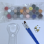 Set of acrylic paints, paint brushes, and a magnifying glass on a white background.