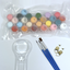 Set of small paint pots in clear plastic, paint brushes and a magnifying glass on a white background.