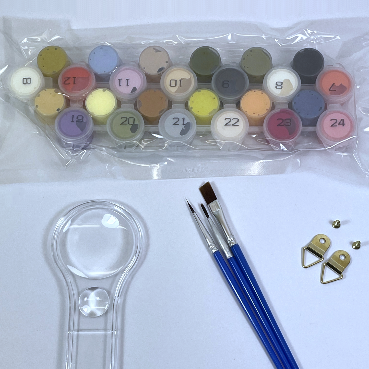 Set of paint pots, paint brushes, and a magnifying glass on a white background.
